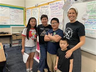 elementary students with parents and teacher in school library