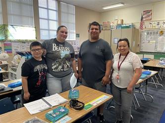 elementary students with parents and teacher in school library