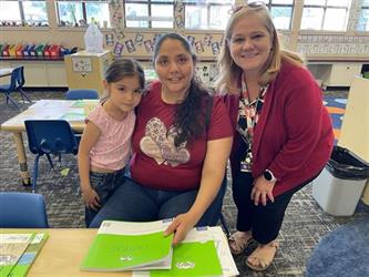 elementary students with parents and teacher in school library