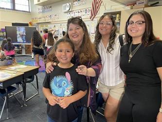 elementary students with parents and teacher in school library
