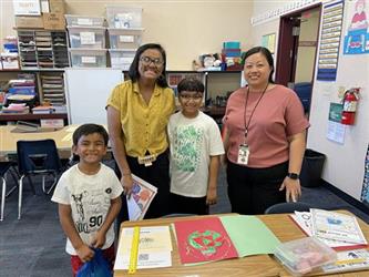 elementary students with parents and teacher in school library